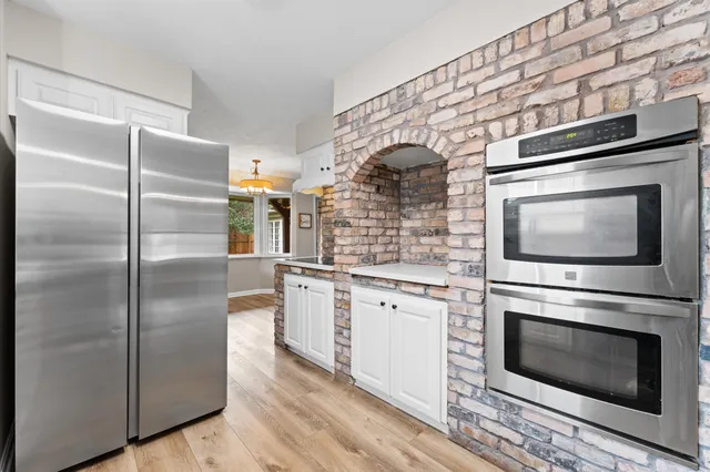 a kitchen with granite countertop stainless steel appliances a stove top oven and cabinets
