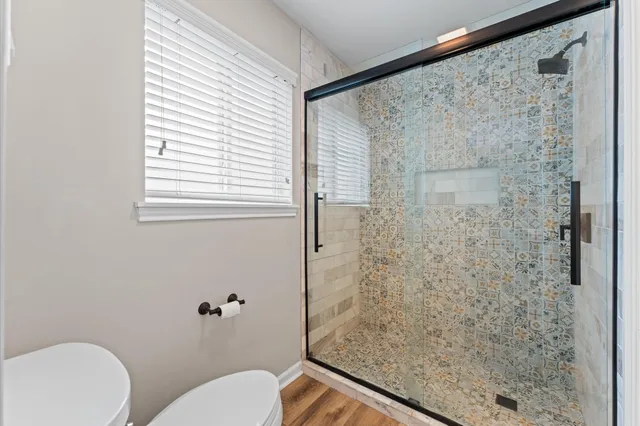 a bathroom with a toilet and a shower