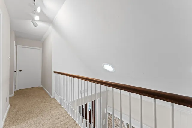a view of a hallway with wooden floor and staircase