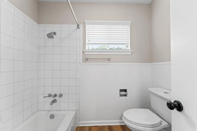 a bathroom with a toilet a sink a window and a shower