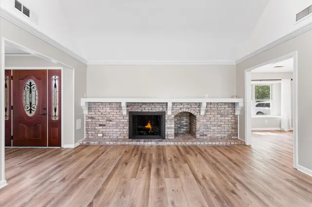 wooden floor fireplace and windows in an empty room