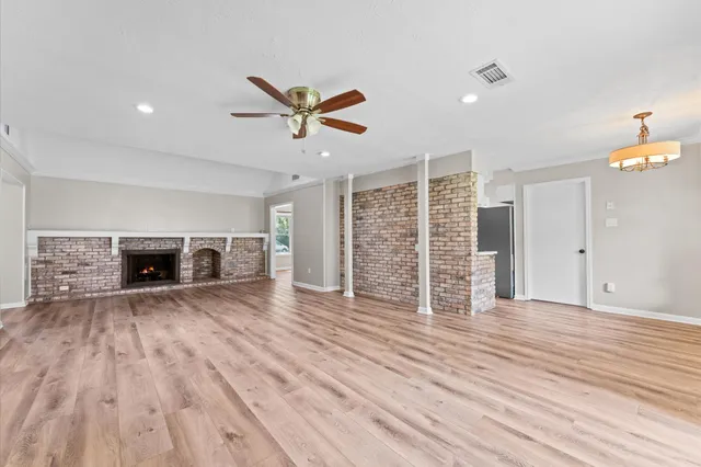 a view of empty room with wooden floor and fireplace