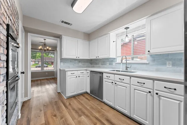 a kitchen with granite countertop white cabinets and white appliances