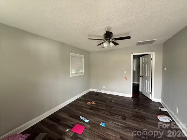 a view of a livingroom with wooden floor and a ceiling fan