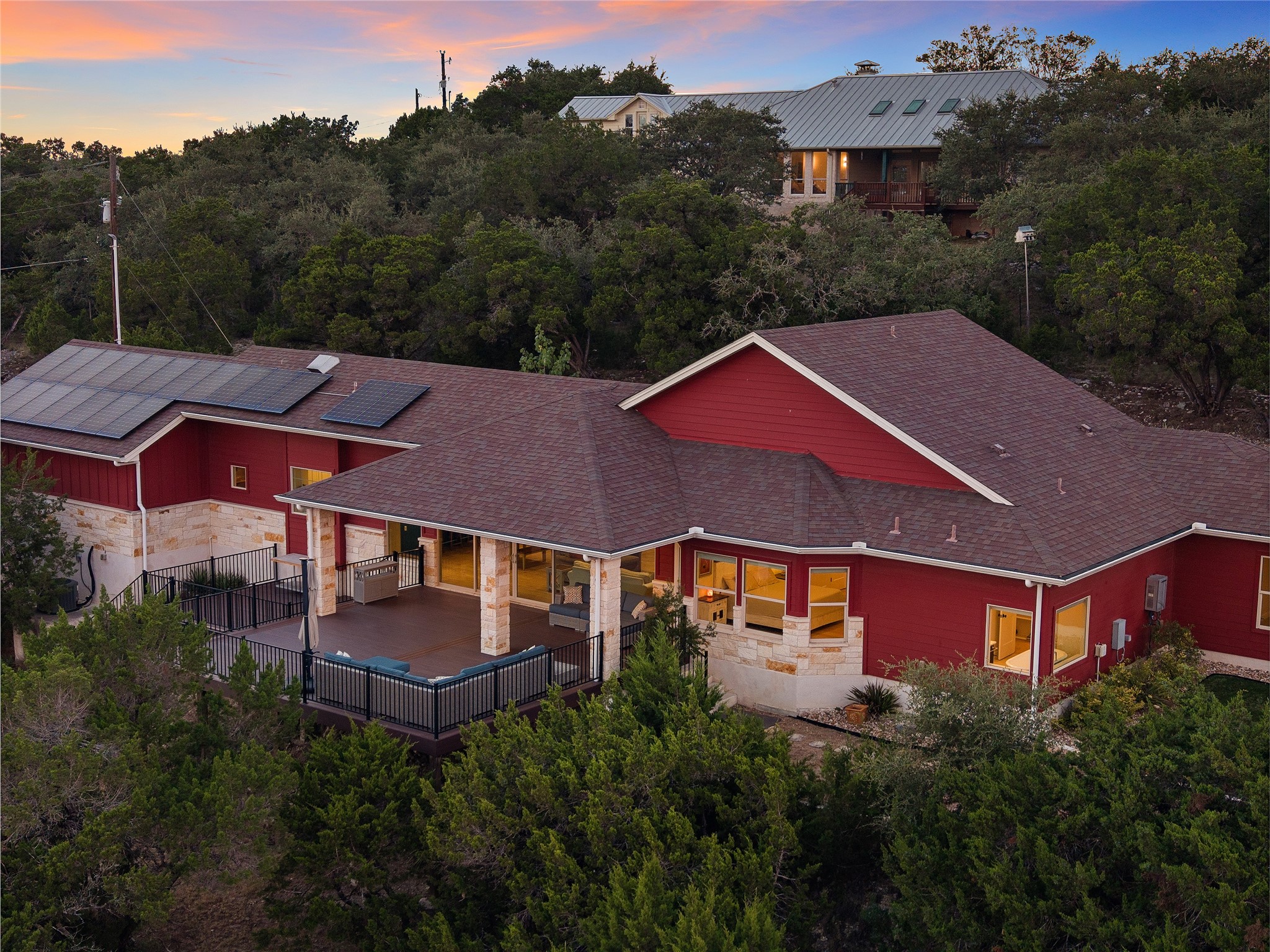 1017 Westland Ridge Road Dripping Springs, TX 78620 - Photo 1 of 40 A spacious elevated deck extends from this hillside home enveloped by mature trees.