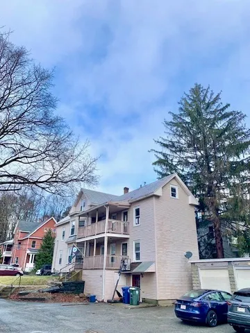 a front view of a house with cars parked