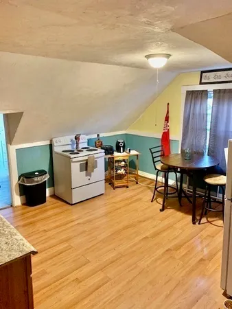 a living room with furniture a flat screen tv and kitchen view