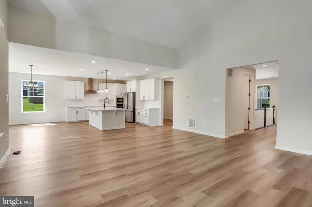 a large kitchen with stainless steel appliances granite countertop a stove a sink and a refrigerator