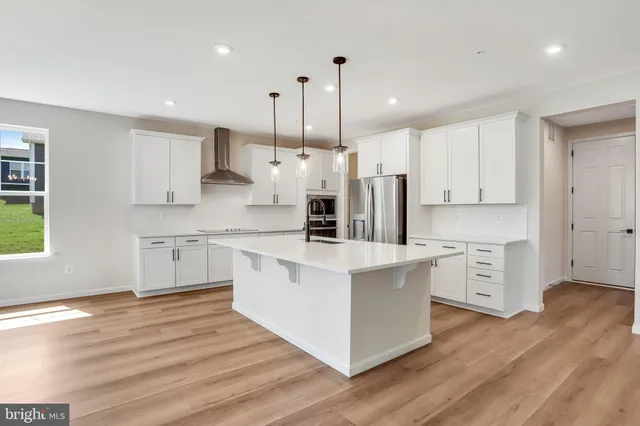 a kitchen with stainless steel appliances granite countertop a stove a sink a center island and a window