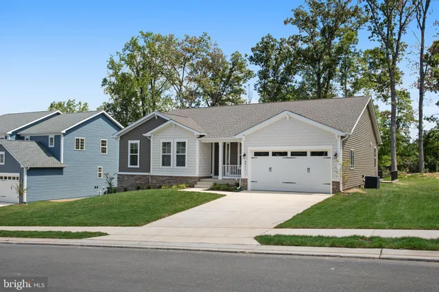 a view of house with a yard and large trees