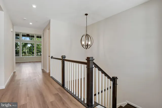 a view of a hallway with wooden floor and windows