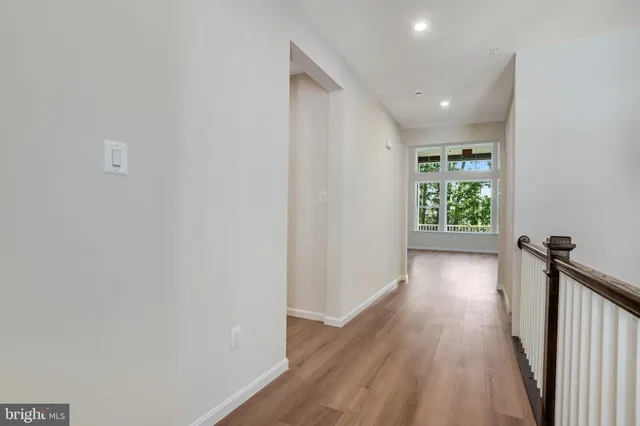 a view of hallway with a window and wooden floor