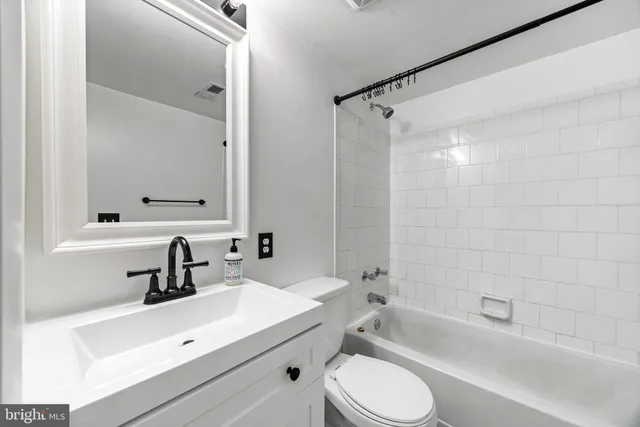 a bathroom with a sink mirror toilet and bathtub