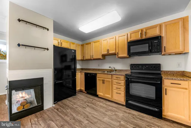 a kitchen with granite countertop a refrigerator stove and microwave