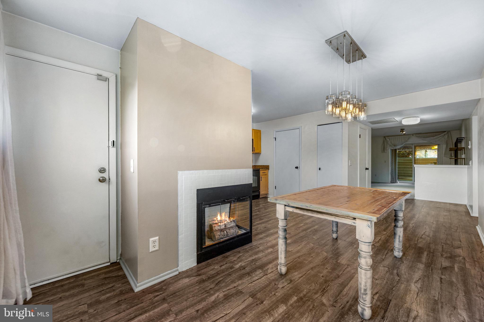 6909 Jones View Drive, Unit 1A Baltimore, MD 21209 - Photo 10 of 30 a room with a fireplace and a chandelier fan