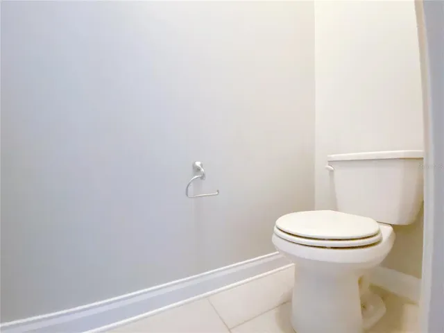 a white toilet sitting next to a white wall