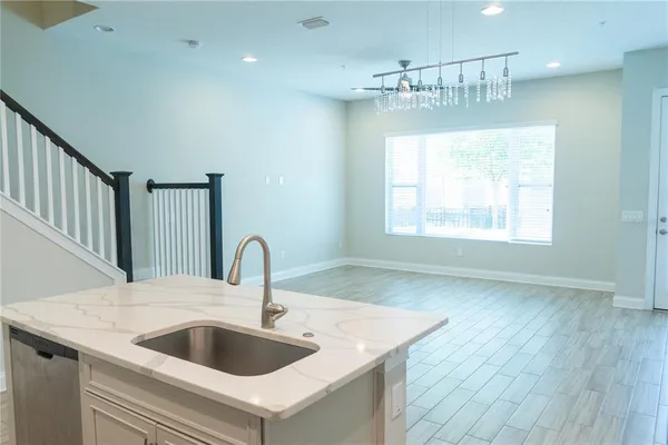 a view of a kitchen with wooden floor and electronic appliances