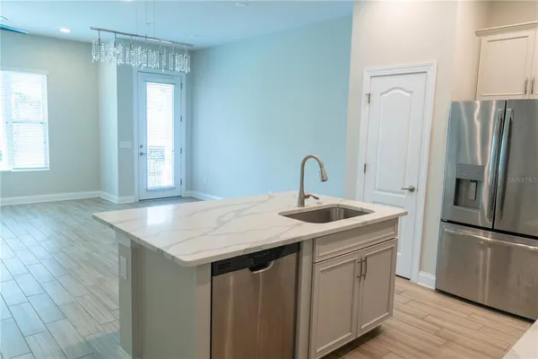 a kitchen with stainless steel appliances a refrigerator and wooden floor