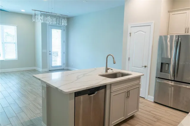 a kitchen with stainless steel appliances a refrigerator and wooden floor