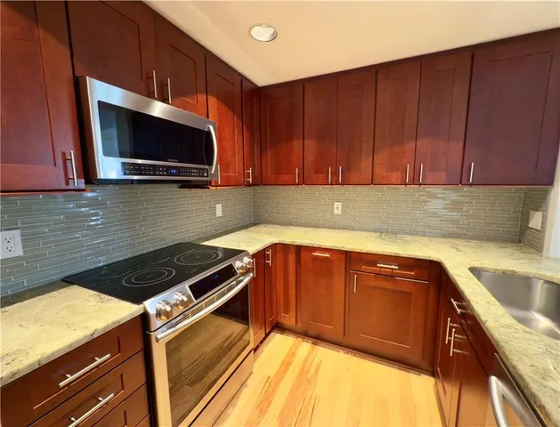 a kitchen with a sink a microwave and cabinets