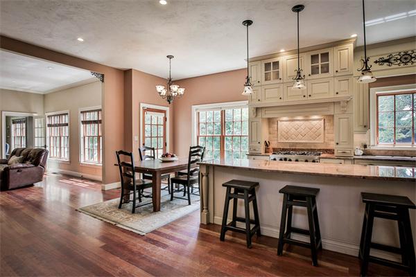 170 Central Avenue Needham, MA 02494 - Photo 8 of 30 a kitchen with stainless steel appliances granite countertop a stove a refrigerator a kitchen island a dining table and chairs with wooden floor
