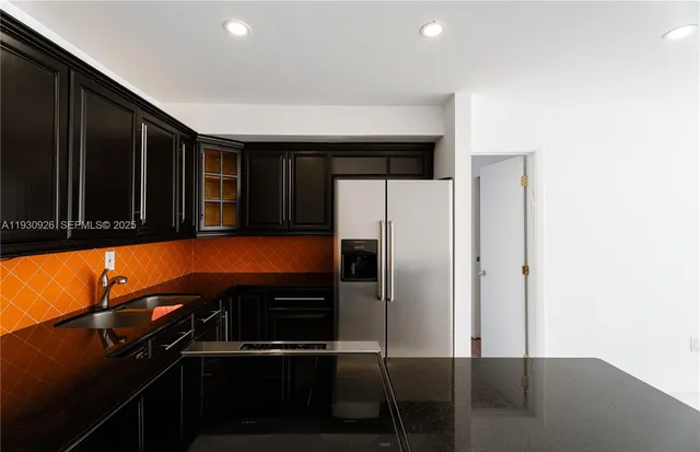 a kitchen with a refrigerator and a stove top oven