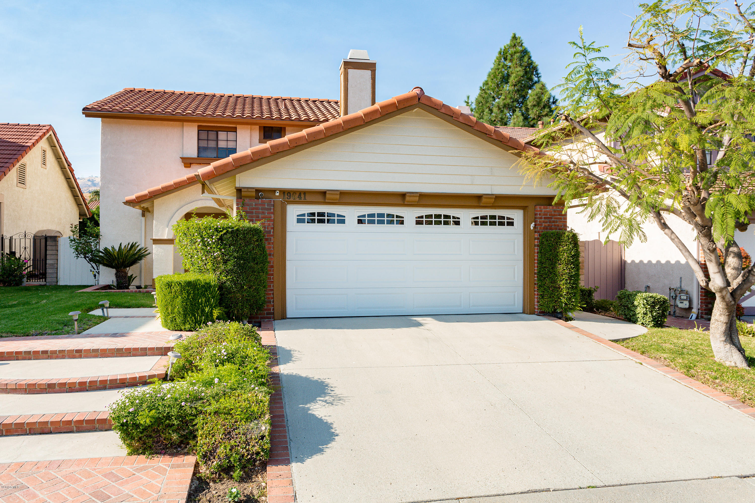 19641 Turtle Springs Way Porter Ranch, CA 91326 - Photo 5 of 31 a front view of a house with a yard and garage