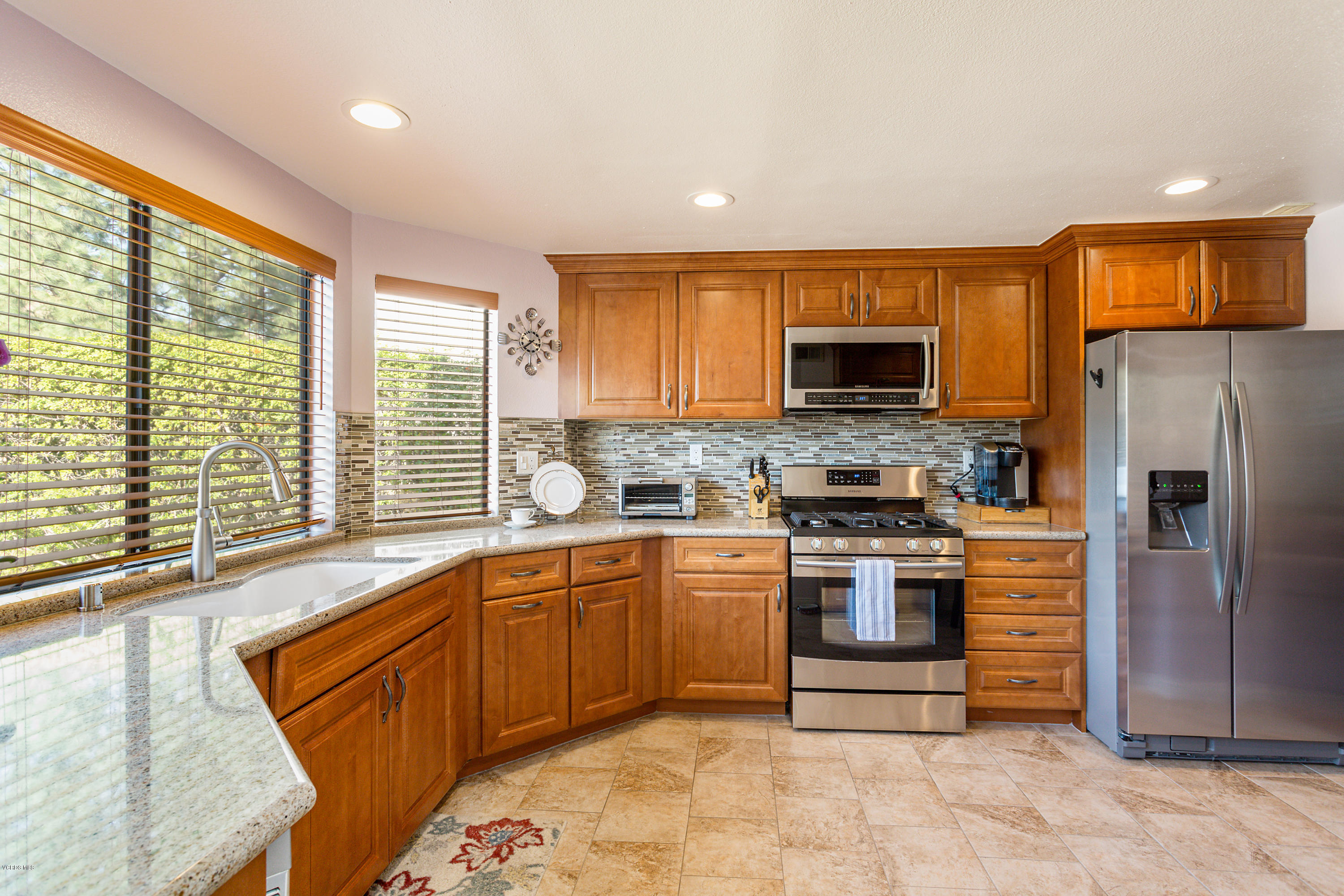 19641 Turtle Springs Way Porter Ranch, CA 91326 - Photo 10 of 31 a kitchen with stainless steel appliances granite countertop a stove top oven a sink and a refrigerator