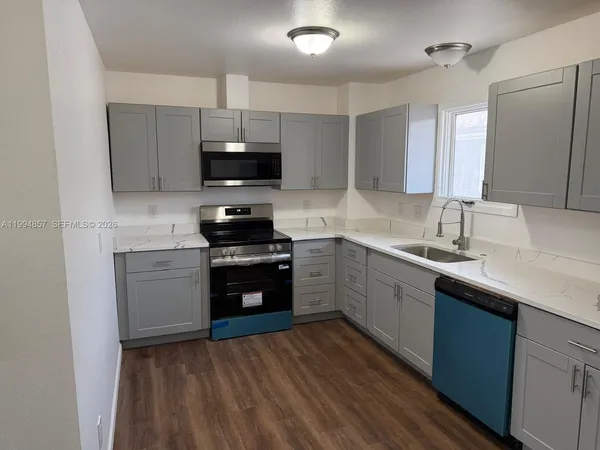 a kitchen with a sink stove and microwave