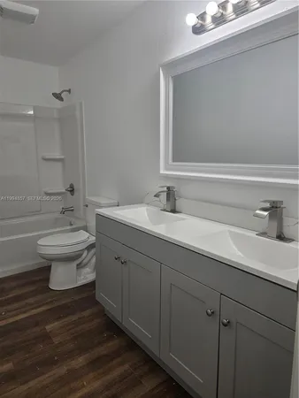 a bathroom with a double vanity sink mirror and toilet