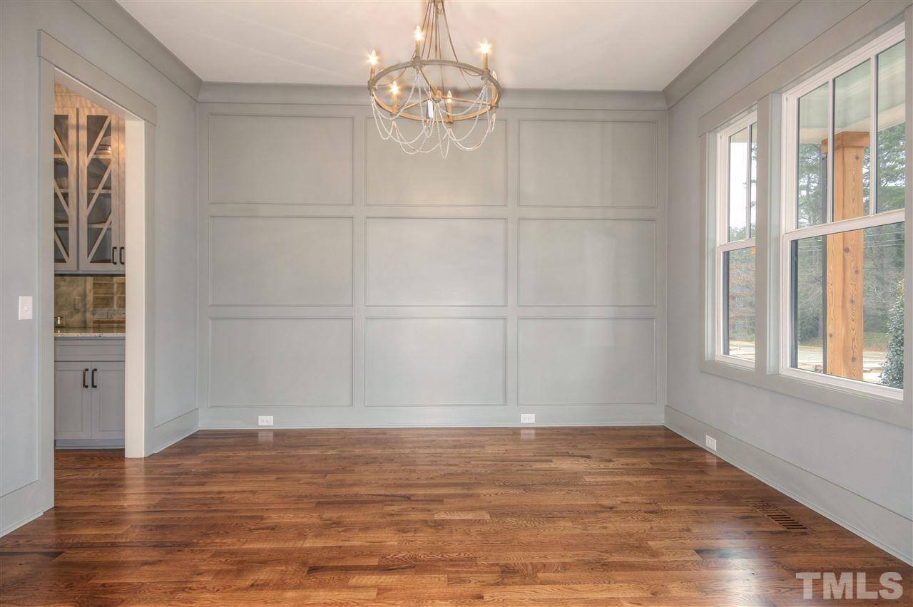 3311 Edgemont Drive Raleigh, NC 27612 - Photo 8 of 30 an empty room with wooden floor cabinet and windows
