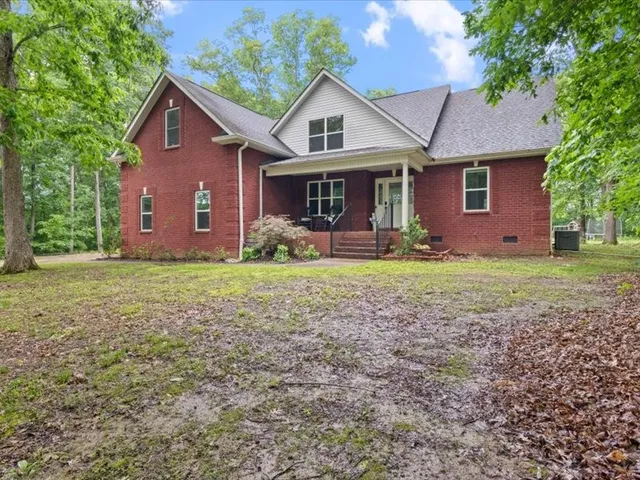 a front view of a house with yard and tree
