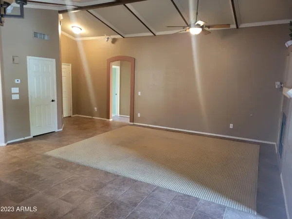 an empty room with a ceiling fan and carpet