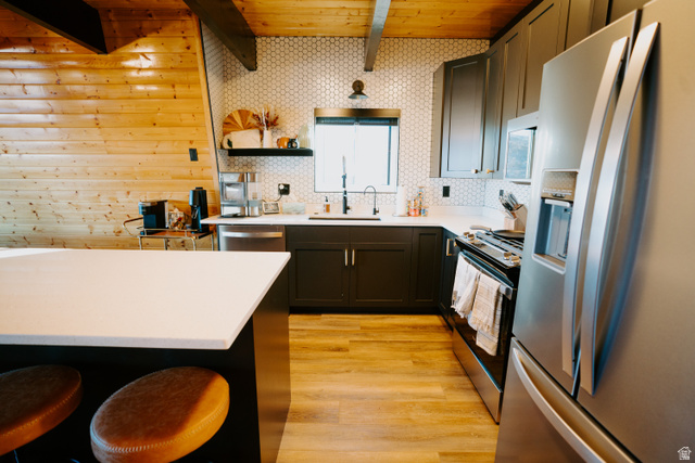 1413 Basel Drive Midway, UT 84049 - Photo 32 of 137 Kitchen with stainless steel appliances, a breakfast bar, light wood-type flooring, open shelves, and a wooden ceiling with exposed beams