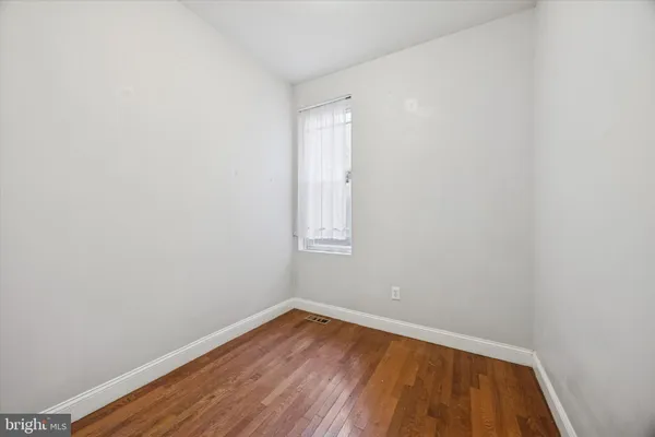 a view of a room with wooden floor and white walls