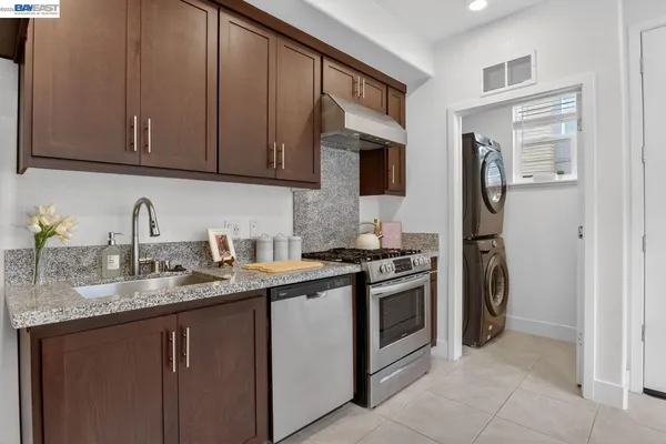 a kitchen with stainless steel appliances granite countertop a sink stove and refrigerator
