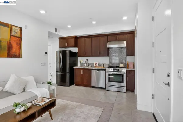 a kitchen with stainless steel appliances granite countertop a refrigerator and a stove top oven