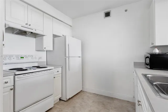 a kitchen with cabinets and stainless steel appliances