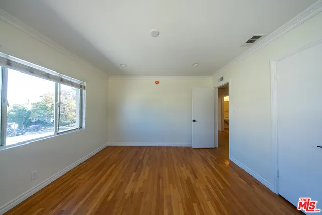 a view of a room with wooden floor and window