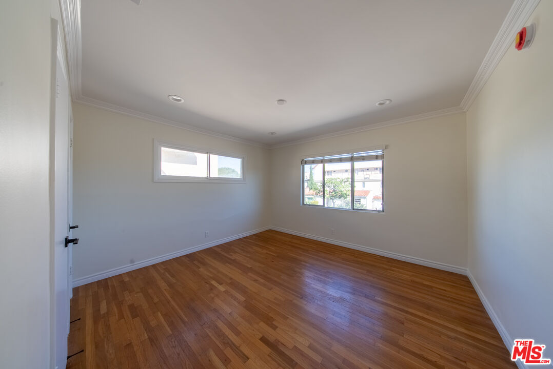 9205 Alcott Street, Unit 4 Los Angeles, CA 90035 - Photo 4 of 7 an empty room with wooden floor and windows