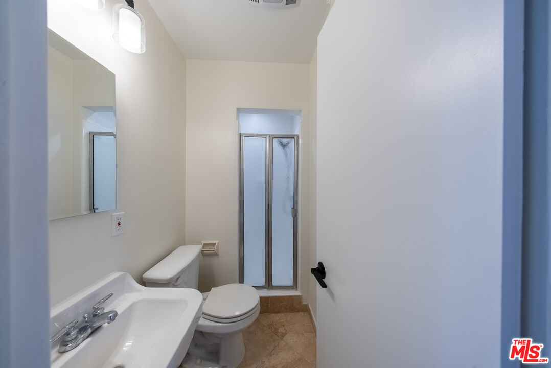 9205 Alcott Street, Unit 4 Los Angeles, CA 90035 - Photo 7 of 7 a white toilet sitting next to a bathroom sink and vanity