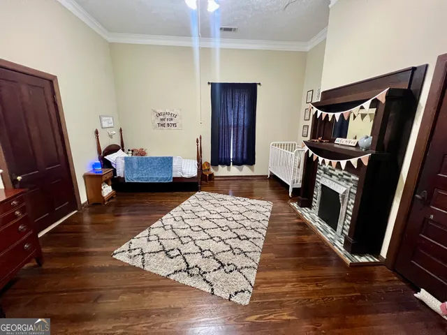 a bedroom with wooden floor and furniture