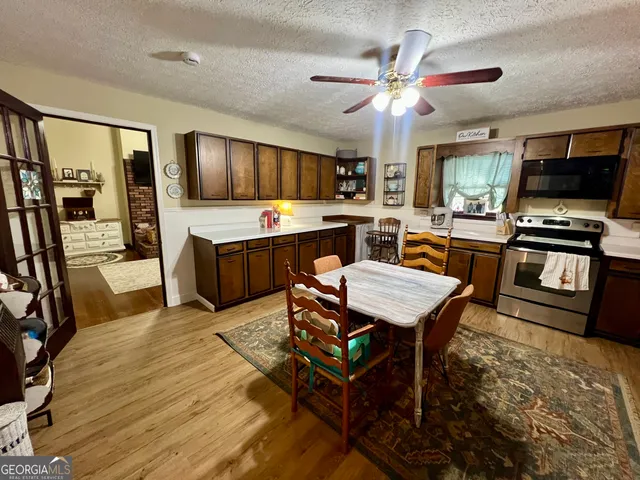 a living room with furniture a flat screen tv and kitchen view