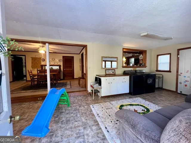 a living room with furniture and a open kitchen view