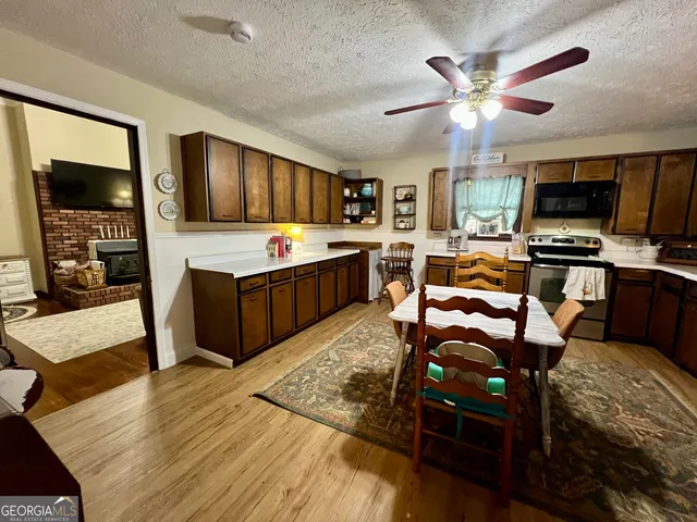 a living room with furniture a flat screen tv and kitchen view