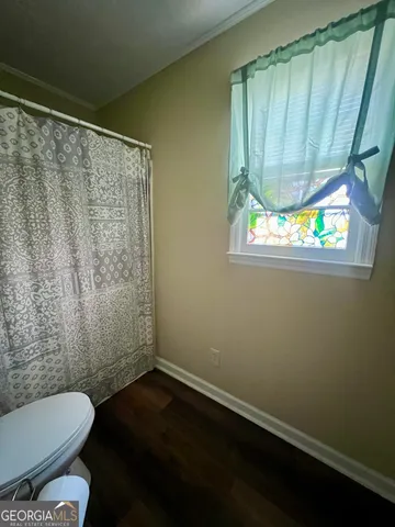 a bathroom with a toilet and a shower curtain