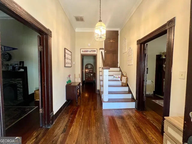 a view of a hallway with wooden floor and staircase