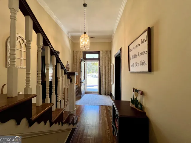 a view of a hallway with wooden floor and staircase