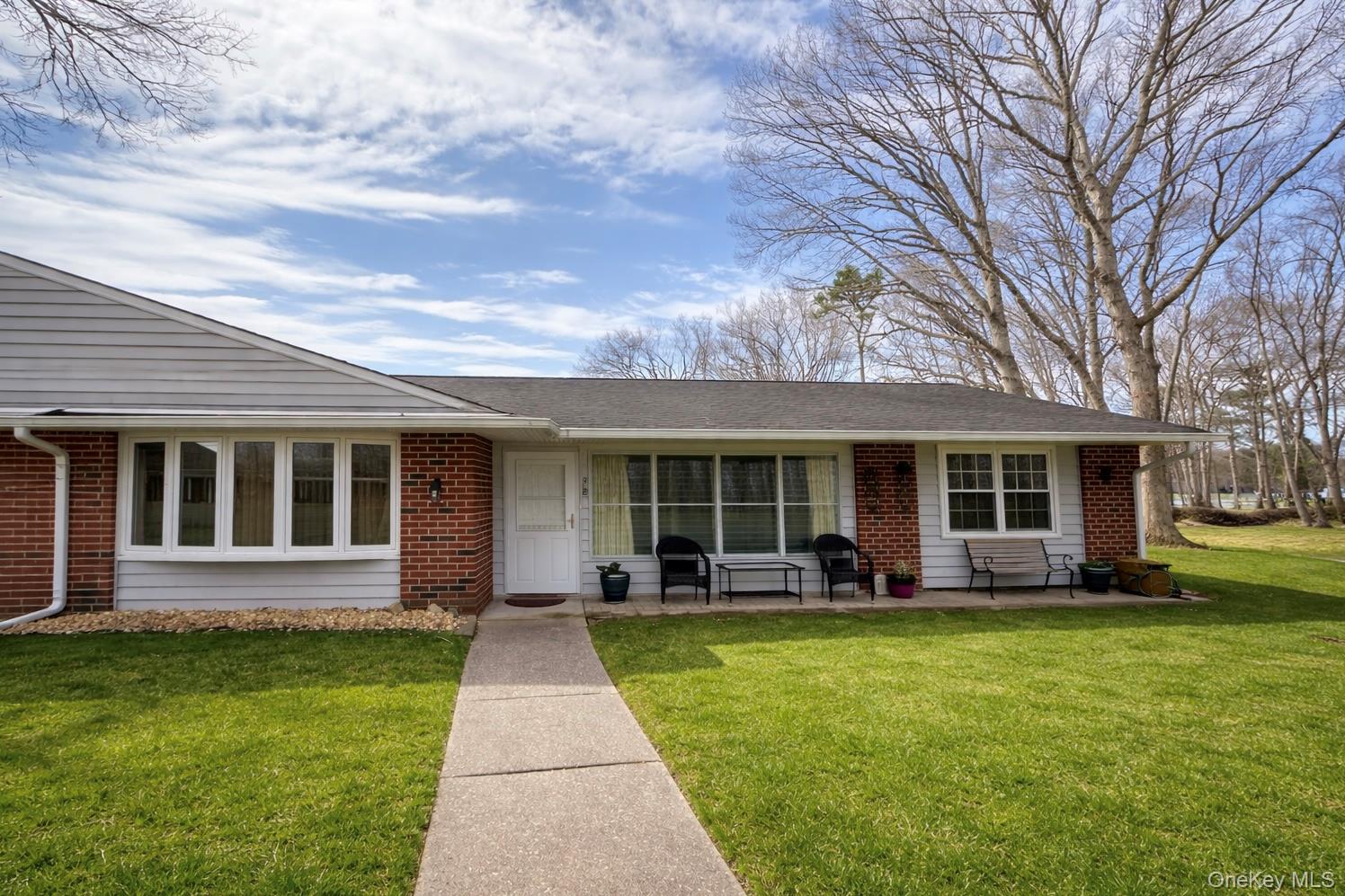 9 Guilford Court, Unit B Ridge, NY 11961 - Photo 2 of 12 a front view of house with yard and green space