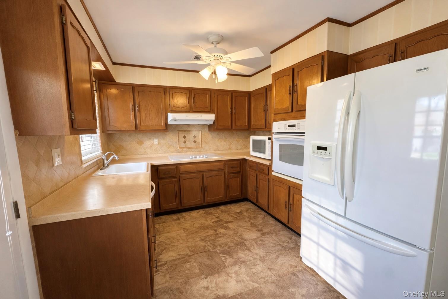 9 Guilford Court, Unit B Ridge, NY 11961 - Photo 8 of 12 a kitchen with stainless steel appliances a refrigerator sink and cabinets